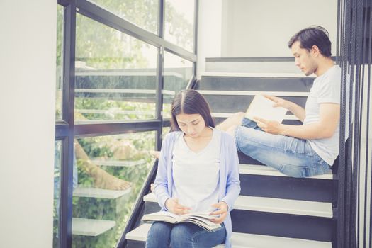 Couple asian handsome man and beautiful woman reading book and smile at home, boyfriend and girlfriend with activities together for leisure, education concept.