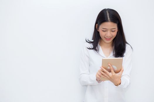 Beautiful portrait young asian woman using tablet computer cement background, businesswoman sitting looking tablet, communication concept.