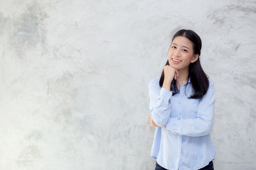 Portrait of beautiful young asian woman happiness standing on gray cement texture grunge wall background, businesswoman is a smiling on concrete, business people concept.