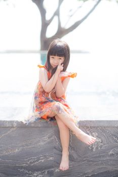 Beautiful portrait little girl asian of a smiling standing at swimming pool, kid leisure and joyful in outdoor.