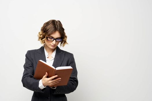 Business woman in a classic suit with a notebook in her hand and glasses on her face Copy Space. High quality photo