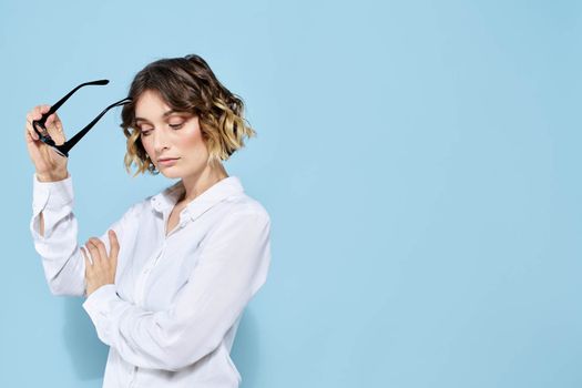 Business woman in a light shirt on a blue background gestures with her hands emotions model work. High quality photo