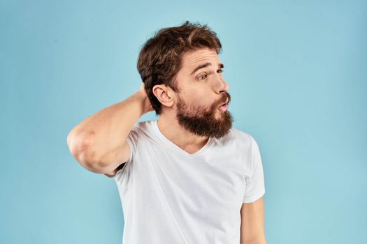 Emotional man with a beard in a white t-shirt blue background fun lifestyle. High quality photo