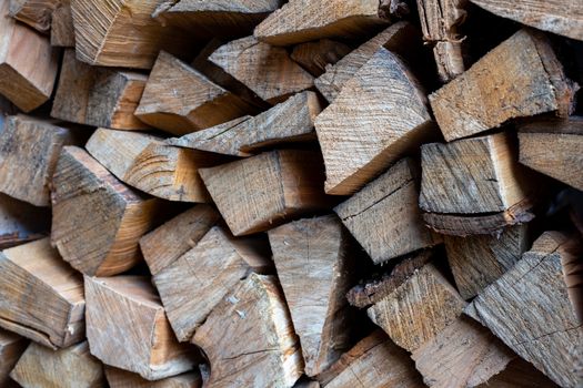 Firewood is stacked one on top of the other. Background texture. Vertical photo.