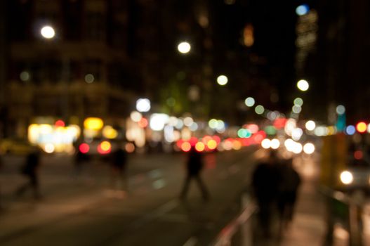 Defocused abstract background of people walking at night in busy city in Winter