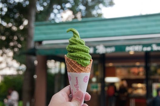 Left hand holding Green tea matcha flavour soft serve ice cream in Tokyo
