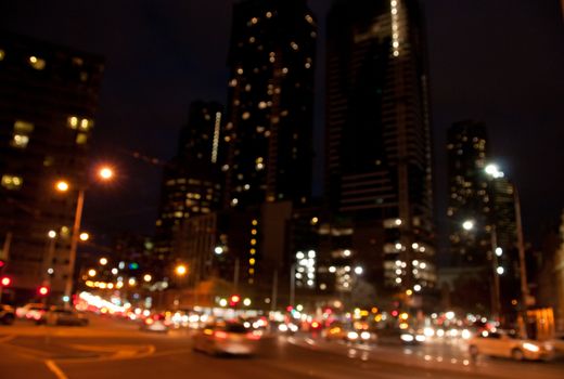 Defocused night scene of modern metropolis with high rise apartment