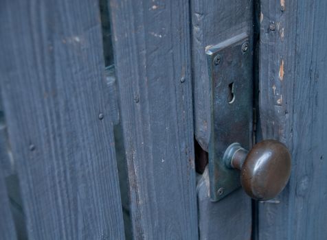 Round classic metal lock with key hold on wooden door