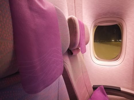 Pink economy seats of airplane at night