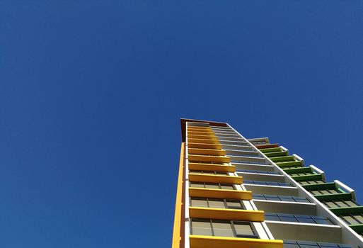 Modern high rise yellow apartment and blue sky