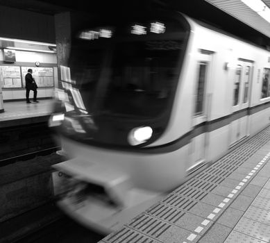 Moving locomotive train to the station in black and white