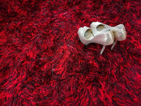 Silver shiny high-heeled shoes stiletto on red carpet