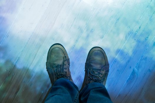 Brown leather shoes and blue jeans standing on a floor