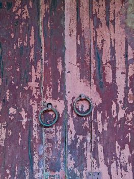 Old vintage rustic maroon wooden door closed