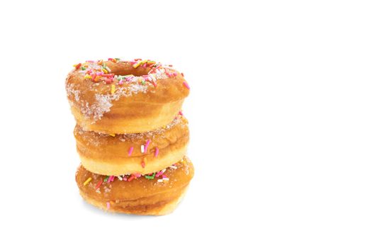 A pile of traditional sugar donuts with multi color sprinkles, isolated on white background.