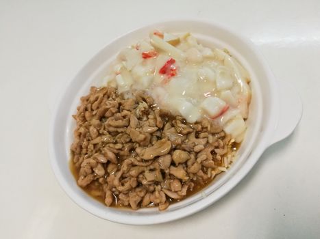 Two tones Chinese Hokkian fried rice in white plate. The left side is soy sauce minced pork, and the right side is a seafood stir fried.