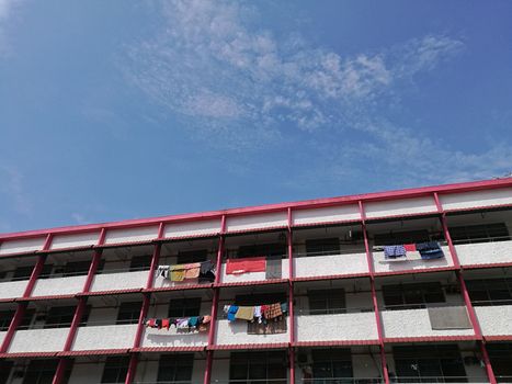 Red white residential flat apartment with cloths hanging in Penang Malaysia