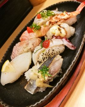 Premium fresh seafood sushi served in black platter.