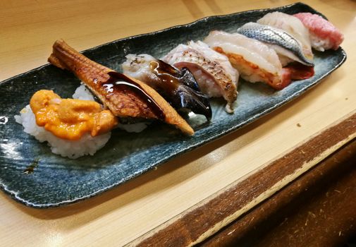 Premium fresh seafood sushi served in a row. There are sea urchin roe and unagi grilled sea fish