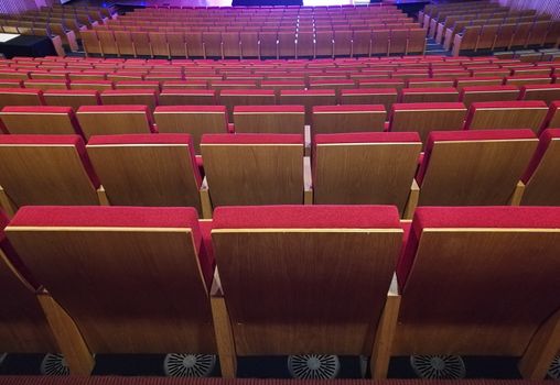 Red seats on a wide stage theater