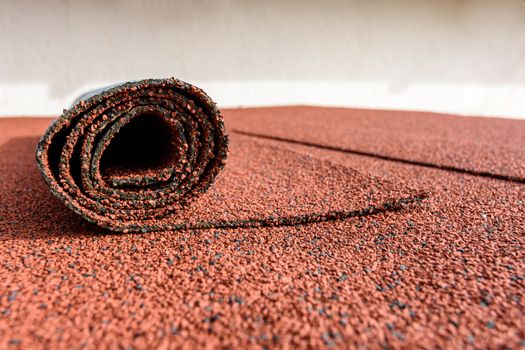 Bitumen roll shingles are laid on the roof on which a roll of shingles lies