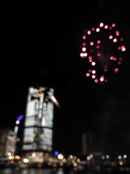 Defocused abstract scene of riverside firework in city center at night to celebrate festive event