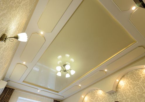 View of a beautiful rich tiered stretch ceiling in gold tones