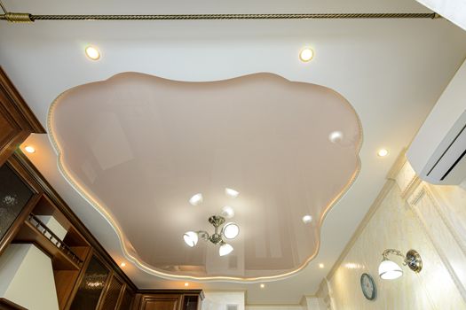 Original stylish multi-level stretch ceiling in the interior of a rich kitchen