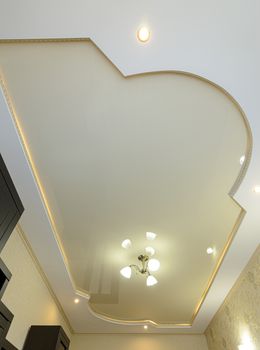 Stretch ceiling with a golden tint with an original shape and design