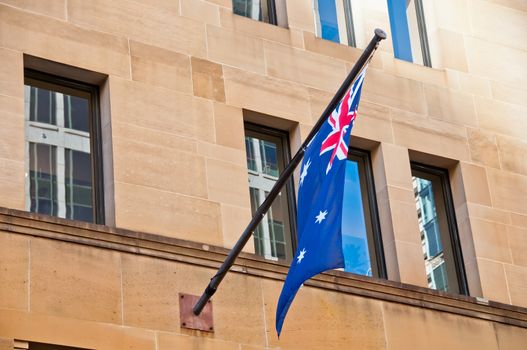 Flag of Australia hang from a sandstone building