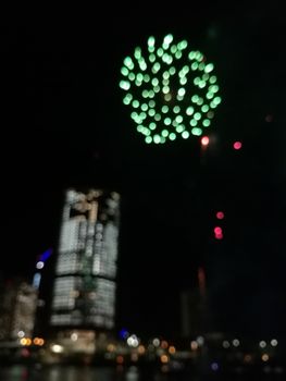 Defocused abstract scene of riverside firework in city center at night to celebrate festive event