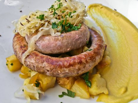 Traditional German grilled bratwurst sausages with mustard sauce on white plate