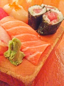 Mixed fresh Japanese sushi platter served on wooden plate and eat with chopsticks