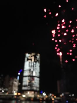 Defocused abstract scene of riverside firework in city center at night to celebrate festive event