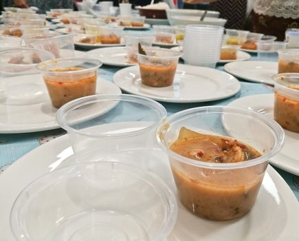 Sample tasting plastic cups of Thailand prawn seafood authentic traditional Tom Yum soup served hot
