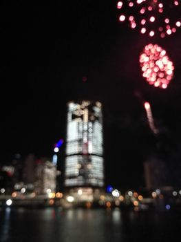Defocused abstract scene of riverside firework in city center at night to celebrate festive event