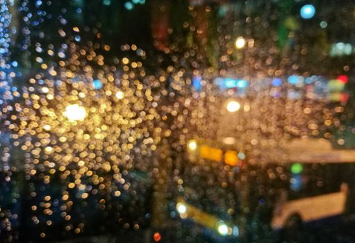 Defocused golden light sparkle scene of city bus in rainy night