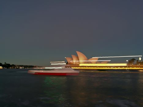 SYDNEY, AUSTRALIA - MAY 5, 2018: Sydney Opera House with a light painting blur motion famous Sydney city ferry in late afternoon and twililght sky.