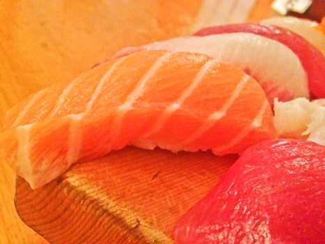 Mixed fresh Japanese sushi platter served on wooden plate and eat with chopsticks