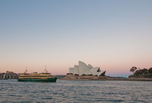 SYDNEY, AUSTRALIA - MAY 5, 2018: Sydney Opera House with famous Sydney city ferry in late afternoon and twililght sky.