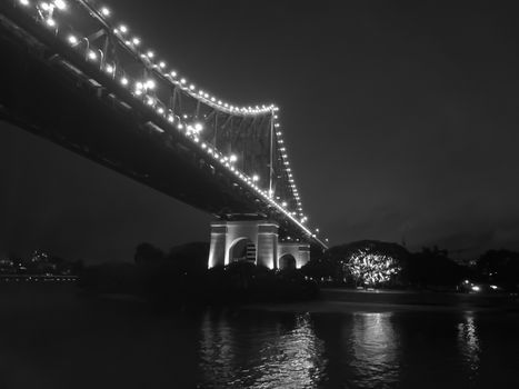 Iconic Brisbane Story Bridge with city skyscrapers at night in black and white