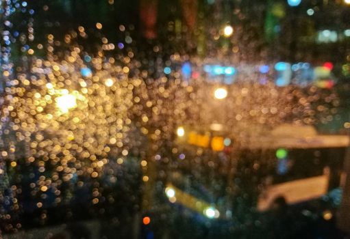 Defocused golden light sparkle scene of city bus in rainy night