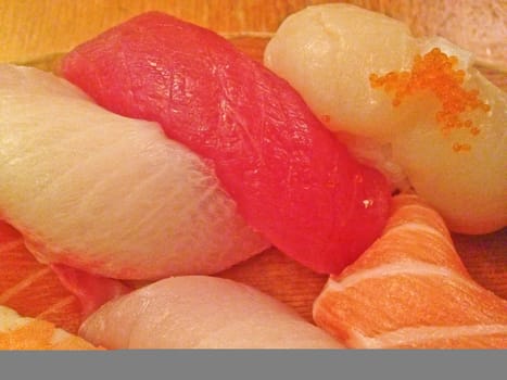 Mixed fresh Japanese sushi platter served on wooden plate and eat with chopsticks