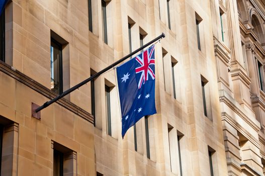 Flag of Australia hang from a sandstone building