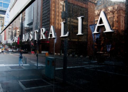 SYDNEY, AUSTRALIA - MAY 5, 2018: Reserve Bank of Australia building name on black stone wall in the center of Sydney NSW Australia. There is a reflection of a woman on the wall.