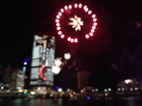 Defocused abstract scene of riverside firework in city center at night to celebrate festive event