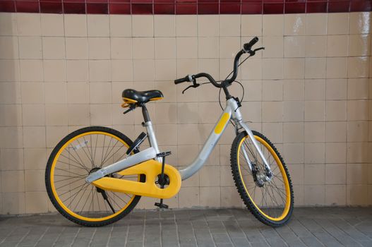 Classic vintage yellow bicycle parking in the city train station wall