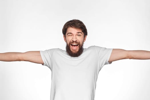 cheerful emotional bearded man gesturing with his hands close-up light background. High quality photo