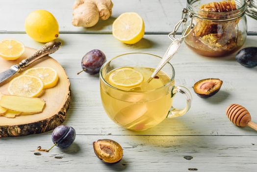 Cup of tea with lemon, honey and ginger over wooden surface