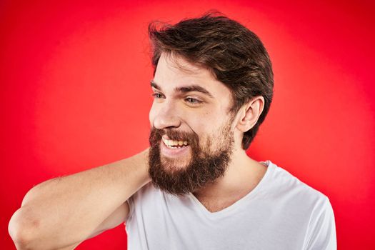 Bearded man fun emotions lifestyle cropped view white t-shirt red background. High quality photo